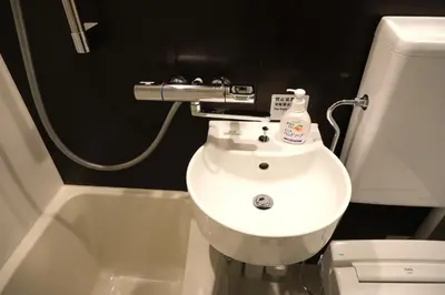 a bathroom with a white sink and a toilet at \u5317\u5ddd\u79cb\u53f6\u539f \u7fbd\u7530\u673a\u573a\u76f4\u8fbe \u79cb\u53f6\u539f\u7ad9\u6b65\u884c4\u5206\u949f\u548c\u98ce\u6c11\u5bbf \u9002\u5408\u5bb6\u5ead\u548c\u60c5\u4fa3\u5165\u4f4f Poka Stay Akihabara in Tokyo
