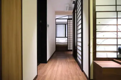 a hallway with a room with a bed in the distance at \u5317\u5ddd\u79cb\u53f6\u539f \u7fbd\u7530\u673a\u573a\u76f4\u8fbe \u79cb\u53f6\u539f\u7ad9\u6b65\u884c4\u5206\u949f\u548c\u98ce\u6c11\u5bbf \u9002\u5408\u5bb6\u5ead\u548c\u60c5\u4fa3\u5165\u4f4f Poka Stay Akihabara in Tokyo
