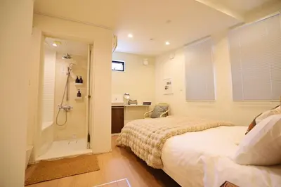 a bedroom with a bed and a walk in shower at Ikebukuro Infinity Grove Villa in Tokyo