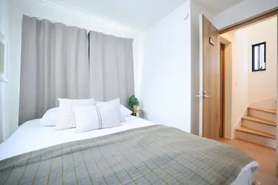 a bedroom with a large bed with white pillows at Ikebukuro Infinity Grove Villa in Tokyo