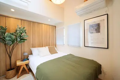 a bedroom with a bed and a potted plant at Ikebukuro Infinity Grove Villa in Tokyo