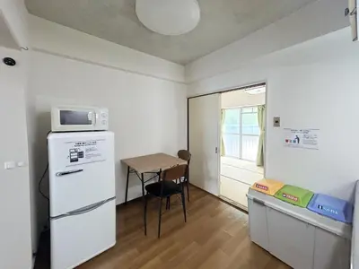 a small kitchen with a small table and a refrigerator at \u99c5\u304b\u3089\u5f92\u6b695\u5206\u6c60\u888b\u307e\u3067\u96fb\u8eca\u30675\u5206\u306e\u597d\u7acb\u5730 in Tokyo