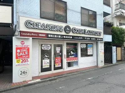 a store on a street with signs on the windows at \u99c5\u304b\u3089\u5f92\u6b695\u5206\u6c60\u888b\u307e\u3067\u96fb\u8eca\u30675\u5206\u306e\u597d\u7acb\u5730 in Tokyo