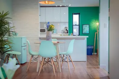 a kitchen with a table and some blue chairs at Shinjuku 'The Wizard of Oz' Villa in Tokyo
