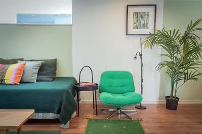 a living room with a green chair and a couch at Shinjuku 'The Wizard of Oz' Villa in Tokyo