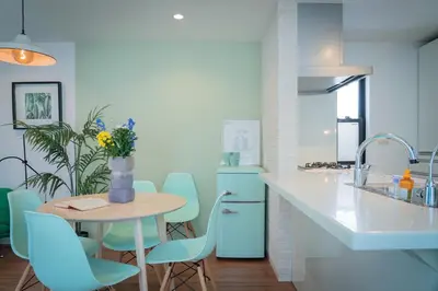 a kitchen with blue chairs and a table and a counter at Shinjuku 'The Wizard of Oz' Villa in Tokyo