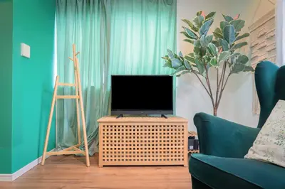 a living room with a tv on a table and a chair at Shinjuku 'The Wizard of Oz' Villa in Tokyo