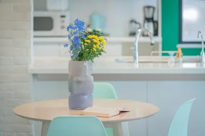 a vase with flowers on a table in a kitchen at Shinjuku 'The Wizard of Oz' Villa in Tokyo