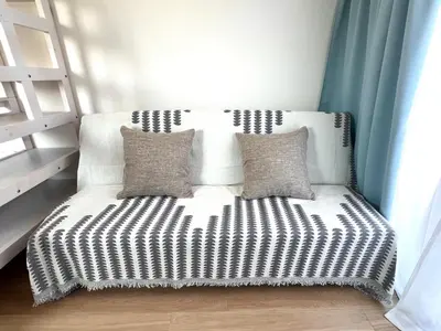 a white couch with two pillows in a room at Suke Home Oshiage in Tokyo