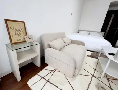 a living room with a chair and a bed at Suke Home Oshiage in Tokyo