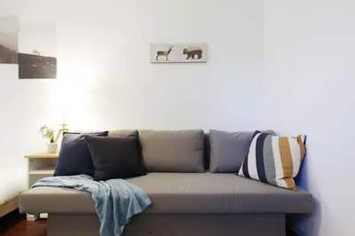 a couch in a living room with a picture of elephants at Suke Home Oshiage in Tokyo