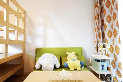 two stuffed animals sitting on a green chair in a room at Suke Home Oshiage in Tokyo