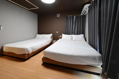 two beds in a small room withskirts at Rakuna Inn \u8679 Oshiage2 in Tokyo