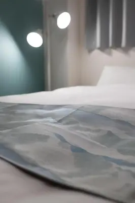 a close up of a bed with white sheets at RENTO Ikebukuro 101 in Tokyo