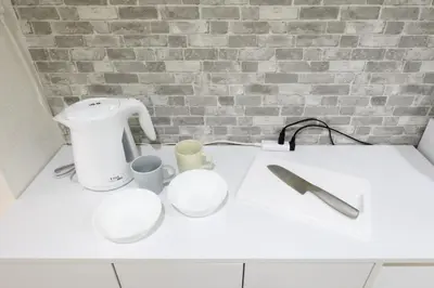 a white counter with two cups and a mixer at RENTO Ikebukuro 101 in Tokyo