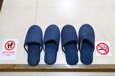 four pairs of blue shoes sitting on a bench next to signs at RENTO Ikebukuro 101 in Tokyo
