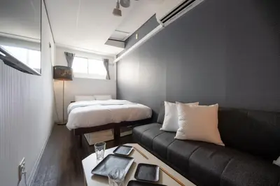 a living room with a couch and a bed at RENTO Ikebukuro 301 in Tokyo