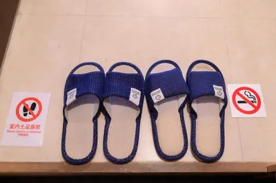 four pairs of blue flip flops on a shelf with signs at RENTO Ikebukuro 301 in Tokyo
