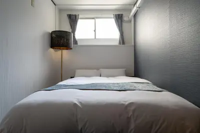 a bedroom with a large bed with a window at RENTO Ikebukuro 301 in Tokyo