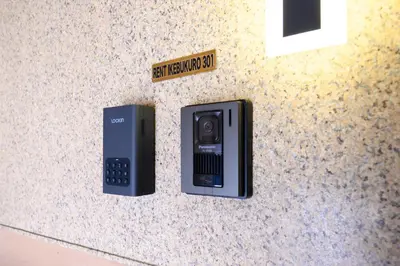 a pay phone sitting on a counter with a sign at RENTO Ikebukuro 301 in Tokyo