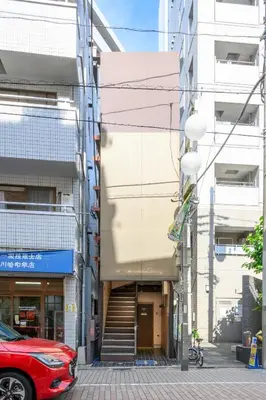 a red car parked in front of a building at RENTO Ikebukuro 301 in Tokyo