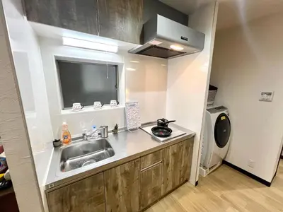 a small kitchen with a sink and a microwave at KAMATA EAST and SWEET in Tokyo