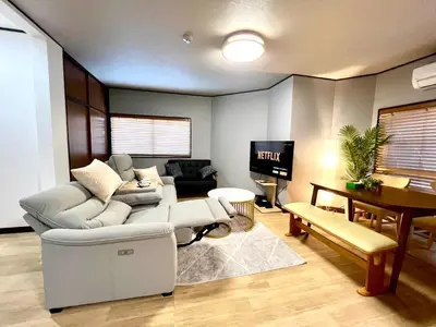 a living room with a white couch and a tv at KAMATA EAST and SWEET in Tokyo