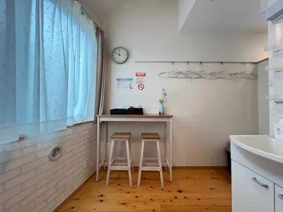 a small kitchen with a table and two stools at nestay suite tokyo mejiro in Tokyo