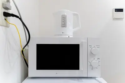 a microwave with a wii controller on top of it at A quiet residential street with a 5-minute walk from Shirokane Takanawa Station! in Tokyo