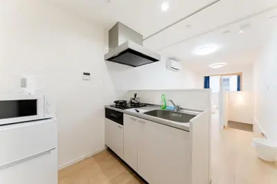 a white kitchen with a sink and a stove at A quiet residential street with a 5-minute walk from Shirokane Takanawa Station! in Tokyo