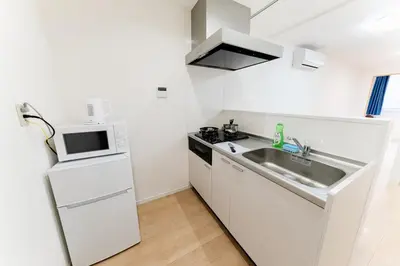 a white kitchen with a sink and a microwave at A quiet residential street with a 5-minute walk from Shirokane Takanawa Station! in Tokyo