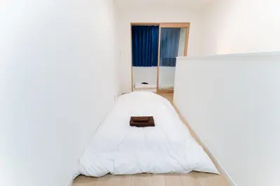 a bed in a white room with a window at A quiet residential street with a 5-minute walk from Shirokane Takanawa Station! in Tokyo