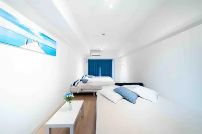 a bedroom with two beds and a table in it at Counte Shinjuku in Tokyo