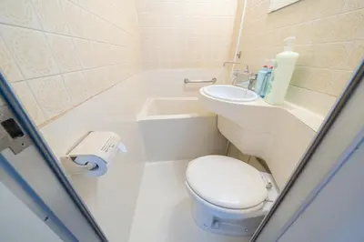a small bathroom with a toilet and a sink at Counte Shinjuku in Tokyo