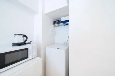 a kitchen with a microwave and a refrigerator at Counte Shinjuku in Tokyo