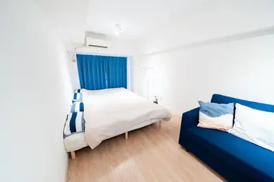 a bedroom with a bed and a blue couch at Counte Shinjuku in Tokyo