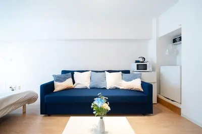 a blue couch with pillows in a living room at Counte Shinjuku in Tokyo