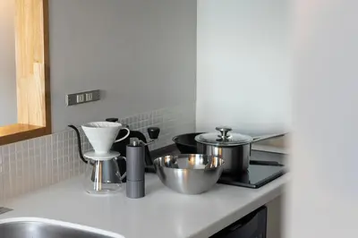 a kitchen counter with pots and pans on a stove at The Apartment Hotel Shibuya 1 in Tokyo