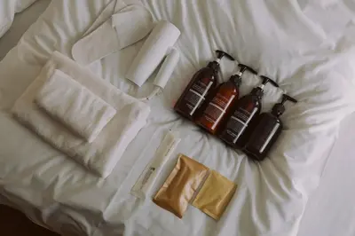 a bed with two towels and two bottles of soap at The Apartment Hotel Shibuya 1 in Tokyo