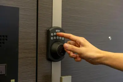 a persons hand pressing a door knob on a door at The Apartment Hotel Shibuya 1 in Tokyo