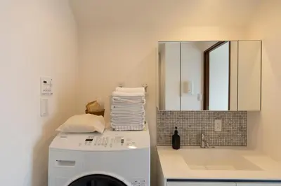 a laundry room with a washing machine and a mirror at The Apartment Hotel Yoyogi 1 in Tokyo