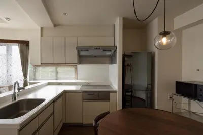 a kitchen with a sink and a table in it at The Apartment Hotel Yoyogi 1 in Tokyo