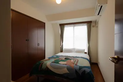 a small bedroom with a bed and a window at The Apartment Hotel Yoyogi 1 in Tokyo