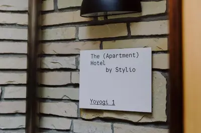 a sign is posted on a brick wall at The Apartment Hotel Yoyogi 1 in Tokyo