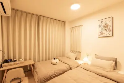 a bedroom with two beds and a teddy bear on the bed at Mars Hotel in Tokyo