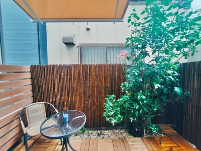 a patio with a table and a tree and a fence at Mars Hotel in Tokyo