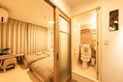 a small room with a bed and a toilet at Mars Hotel in Tokyo