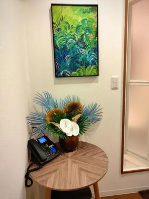 a table with a phone and a painting on the wall at Mars Hotel in Tokyo