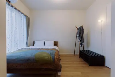 a bedroom with a bed and a large window at The Apartment Hotel Ebisu 1 in Tokyo