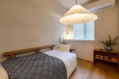 a bedroom with a bed and a large pendant light at The Apartment Hotel Ebisu 1 in Tokyo
